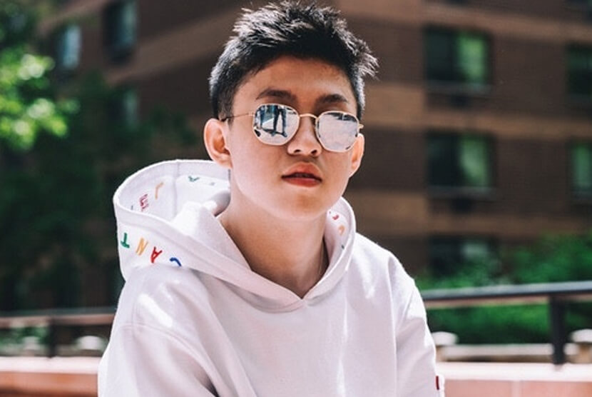 Rich Brian mengenakan hoodie putih dan kacamata hitam